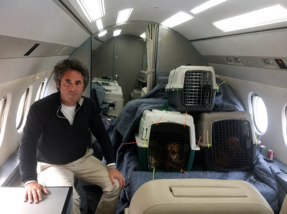 Spencer B. Haber aboard the rescue flight with animals in carriers