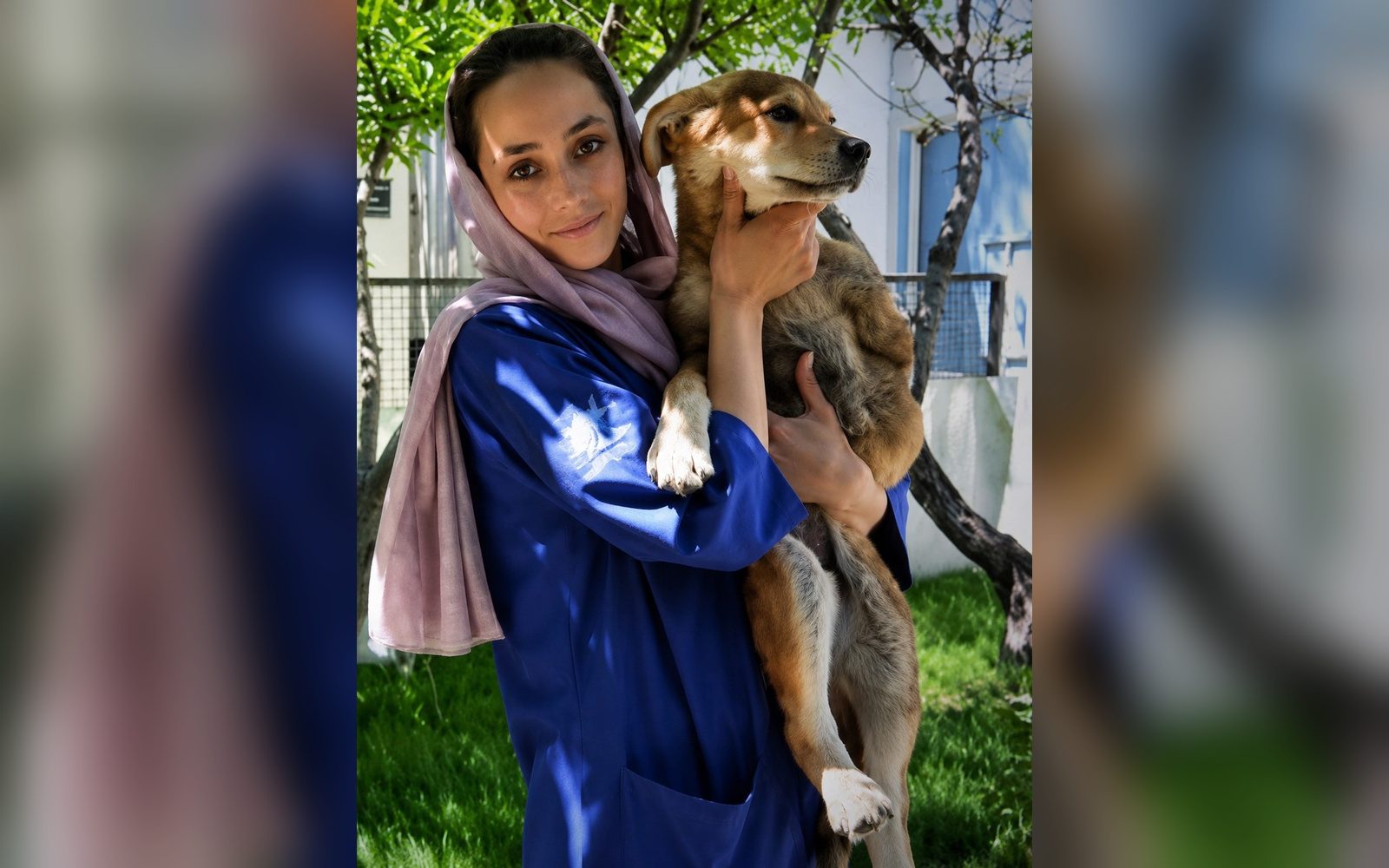 A Nowzad staff member holding a rescued dog at the Kabul clinic