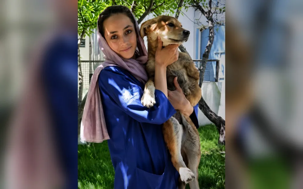 A Nowzad staff member holding a rescued dog at the Kabul clinic