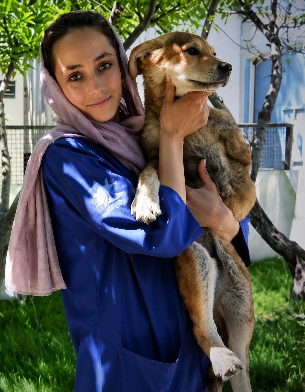 A Nowzad staff member holding a rescued dog at the Kabul clinic